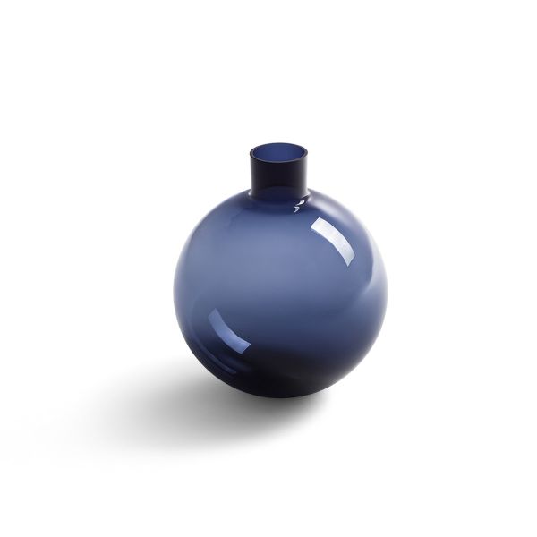 Il vaso Blue Pallo, realizzato per Poltrona Frau dalla prestigiosa vetreria svedese Skruf, mette in risalto la trasparenza della soffiatura del vetro nella suggestiva tonalità blu notte.